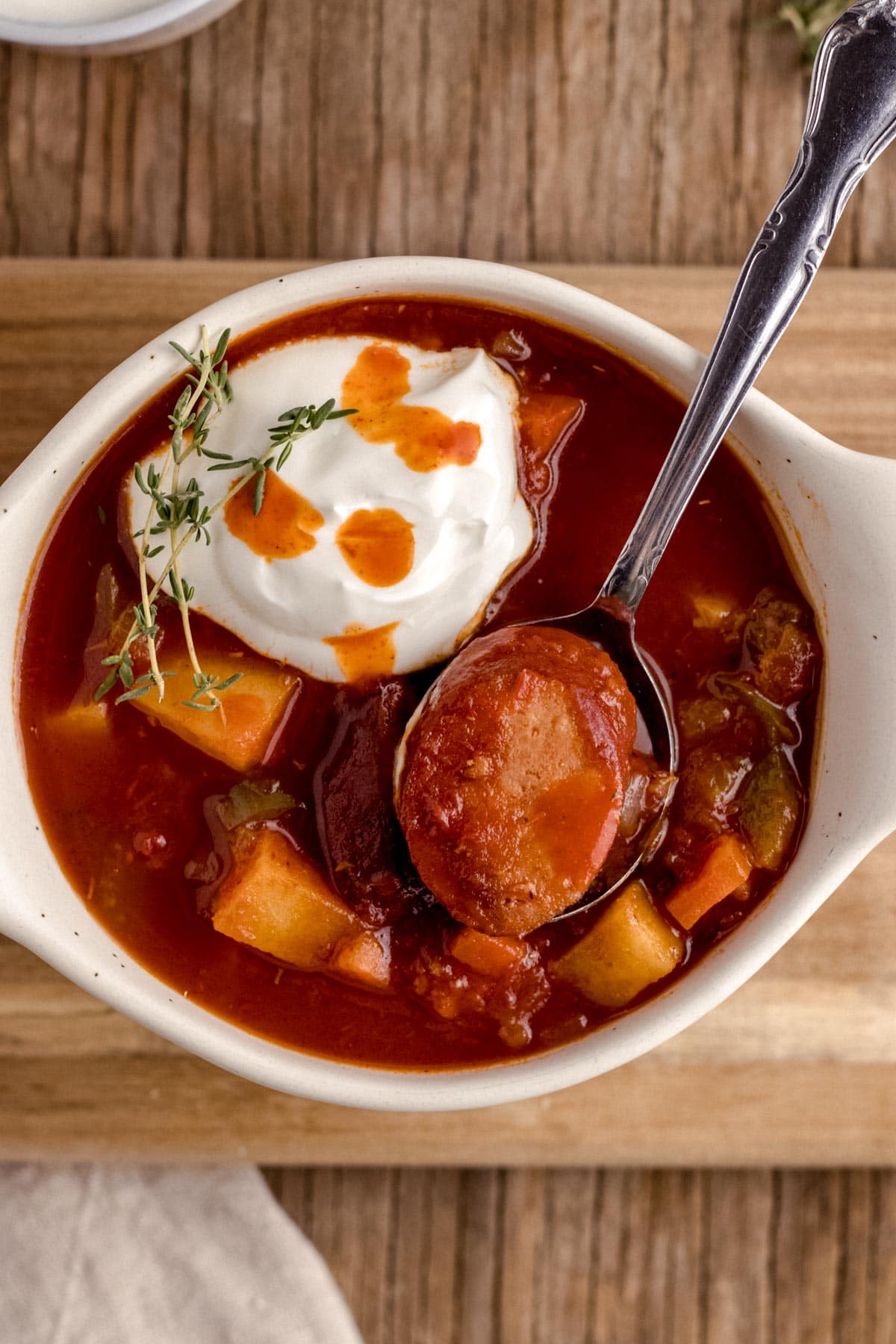 Andouille Sausage Soup in serving bowl with sour cream