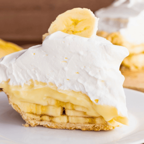 slice of fruit pie with whipped cream on a white plate