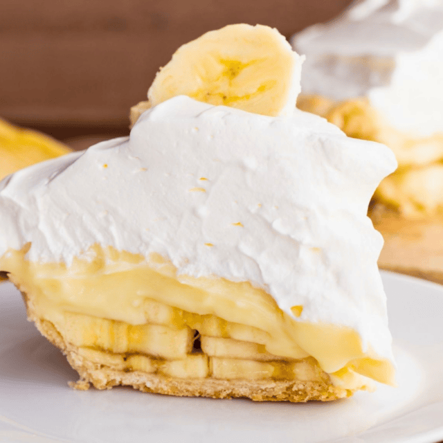 slice of fruit pie with whipped cream on a white plate