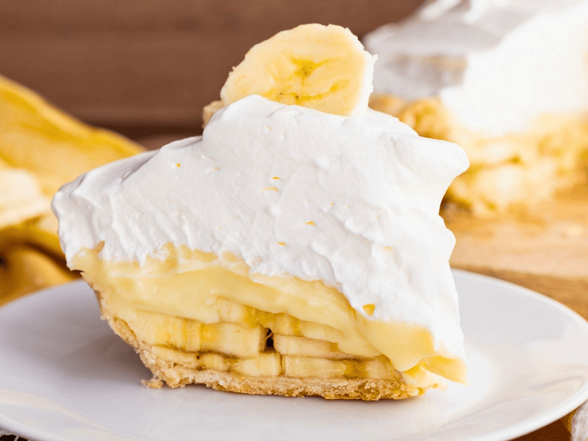 slice of fruit pie with whipped cream on a white plate
