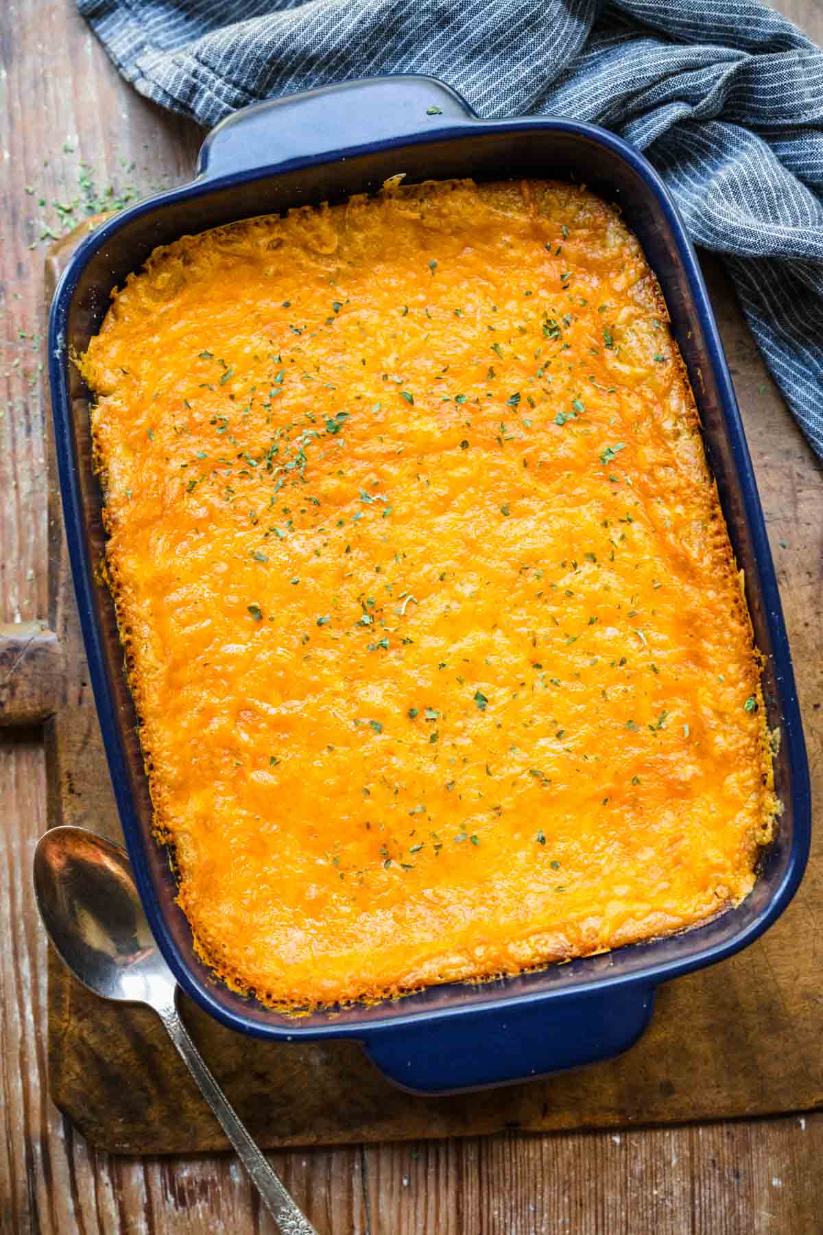 Cheesy Corn Casserole ingredients in casserole dish topped with melty cheese