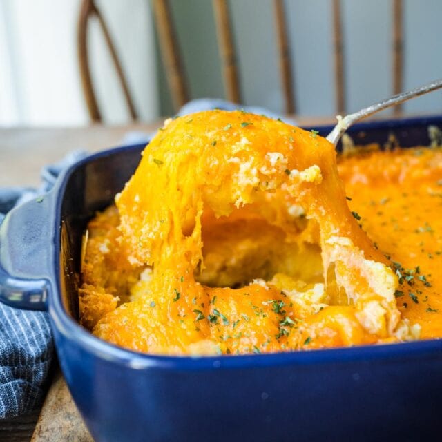 Cheesy Corn Casserole being scooped from casserole dish 1x1