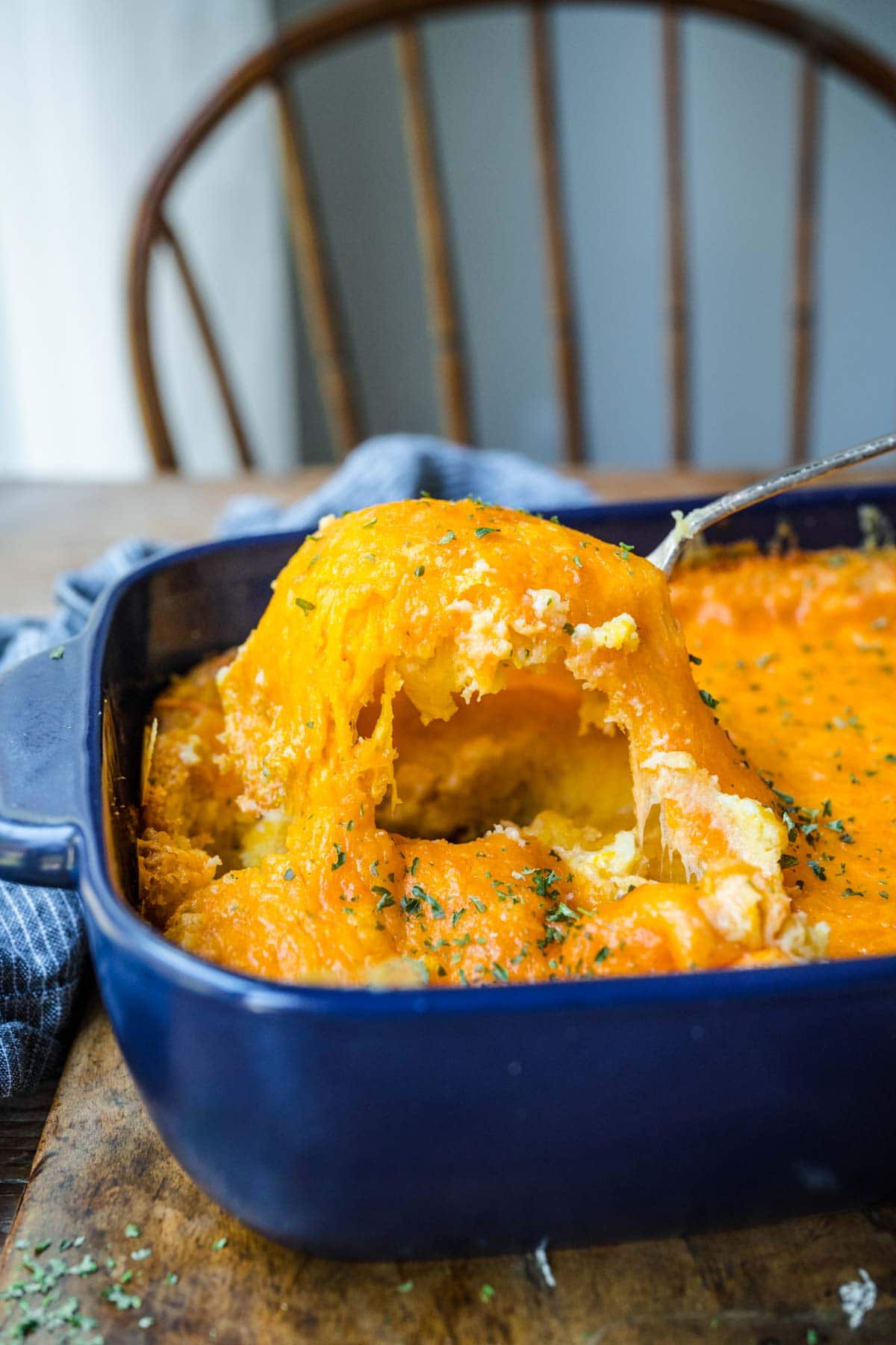 Cheesy Corn Casserole being scooped from casserole dish