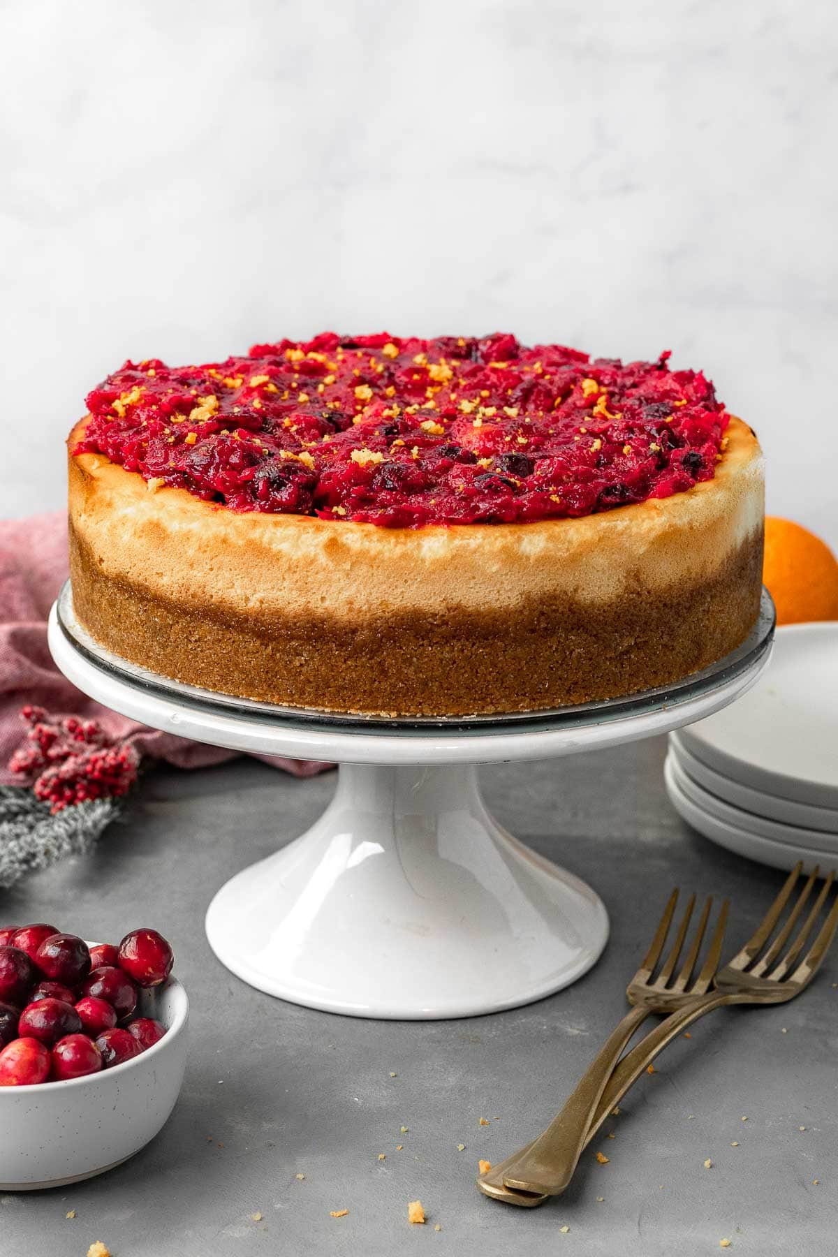 Easy Cranberry Cheesecake on cake stand with cranberry sauce topping