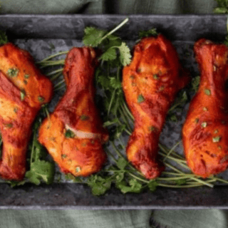 chicken on a platter with cilantro underneath