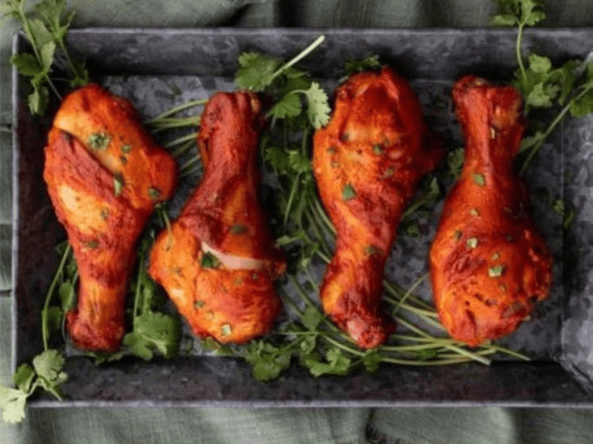 chicken on a platter with cilantro underneath