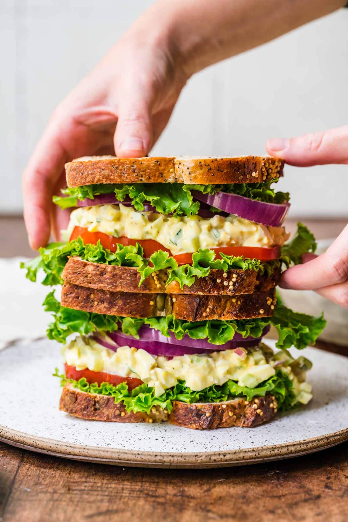 Egg Salad Sandwich stacking sandwiches on serving plate