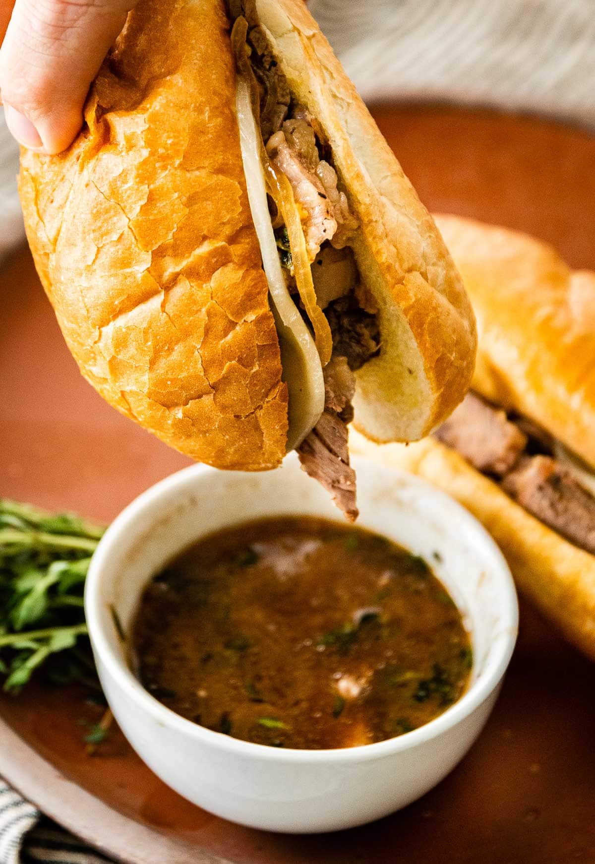 French Dip Sandwiches dipping in au jus