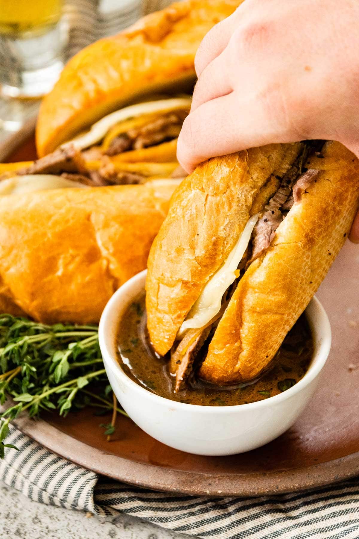 French Dip Sandwiches dipping in au jus