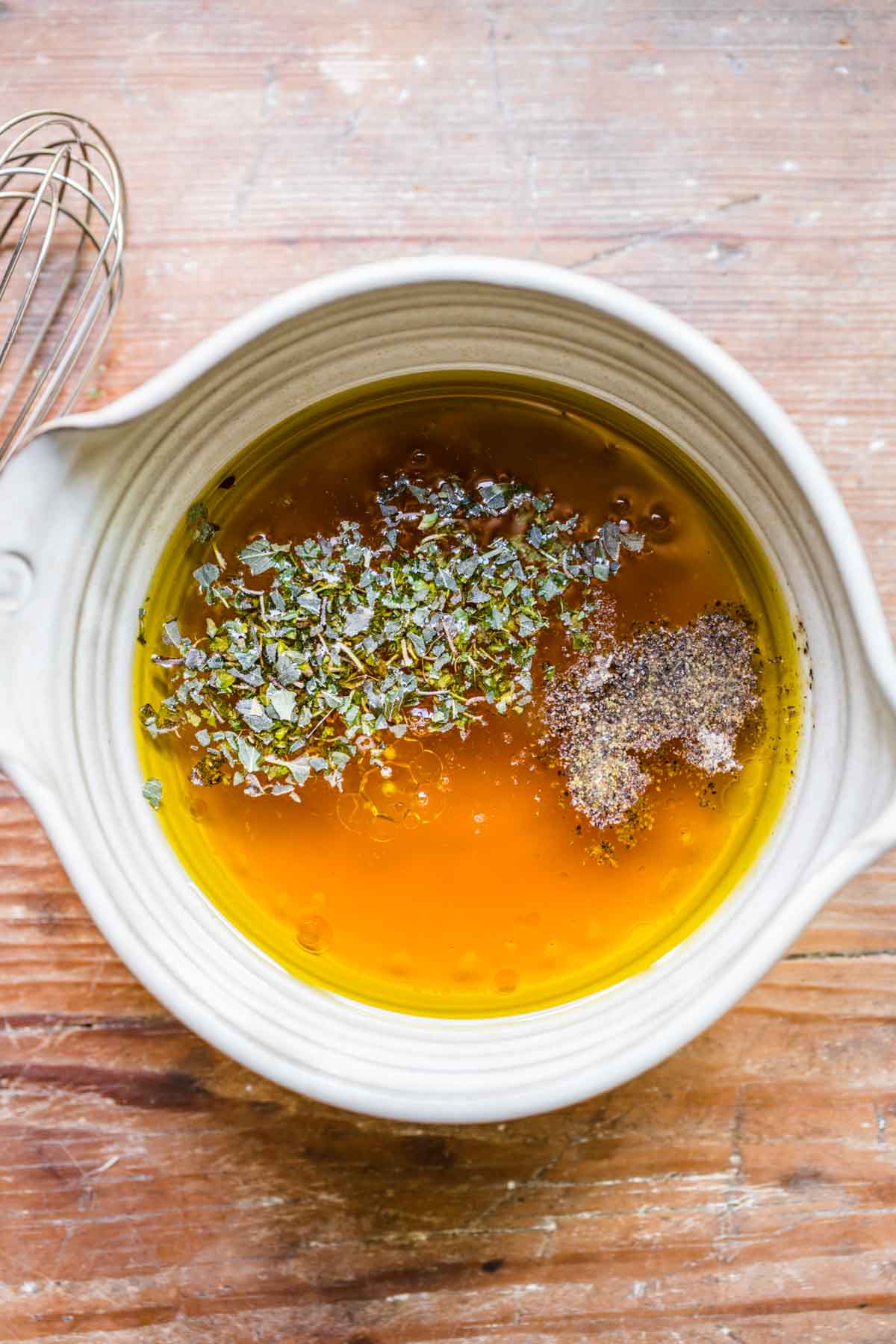 Greek Orzo Salad vinaigrette ingredients in mixing bowl