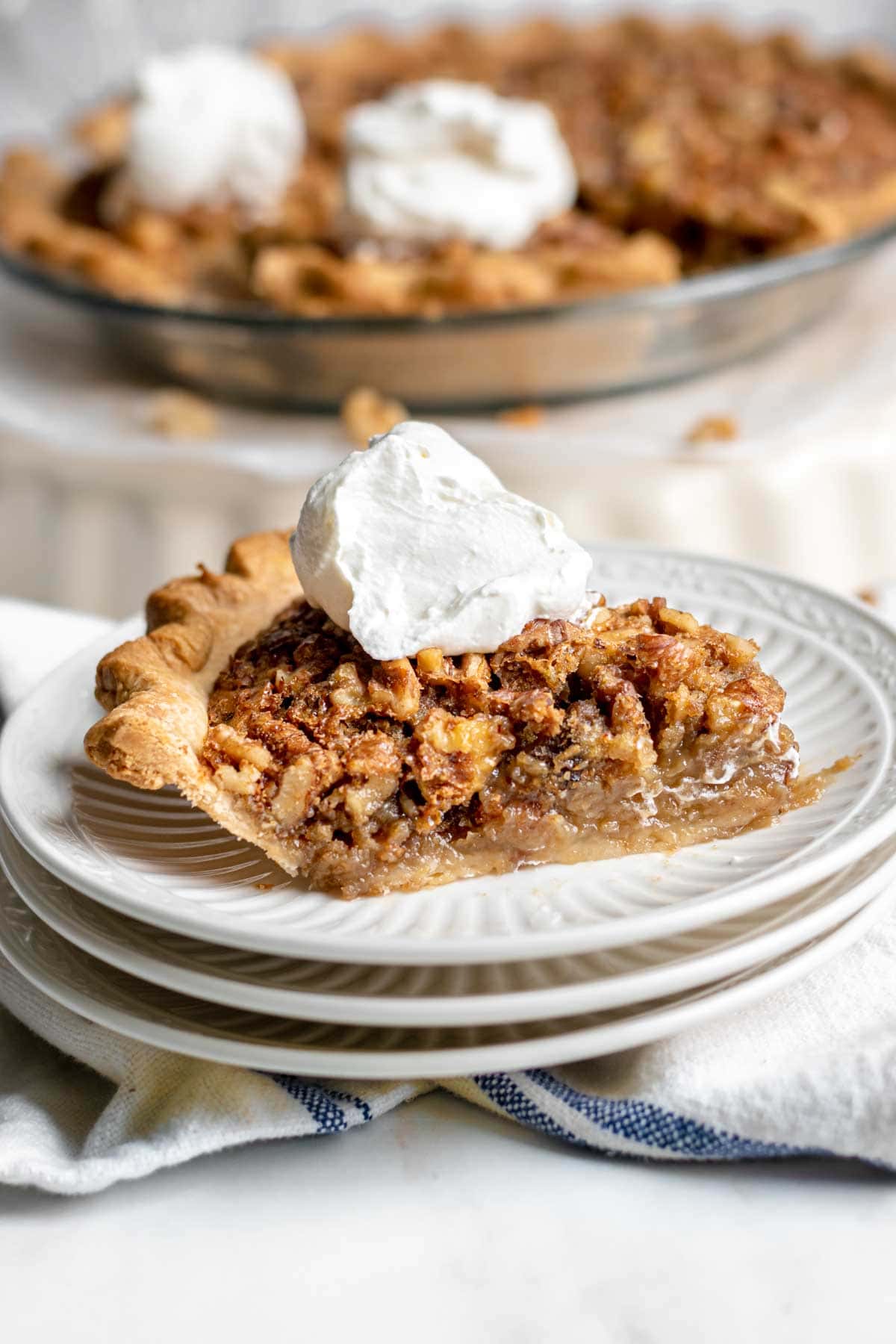 Maple Walnut Pie slice on serving plate with whipped cream