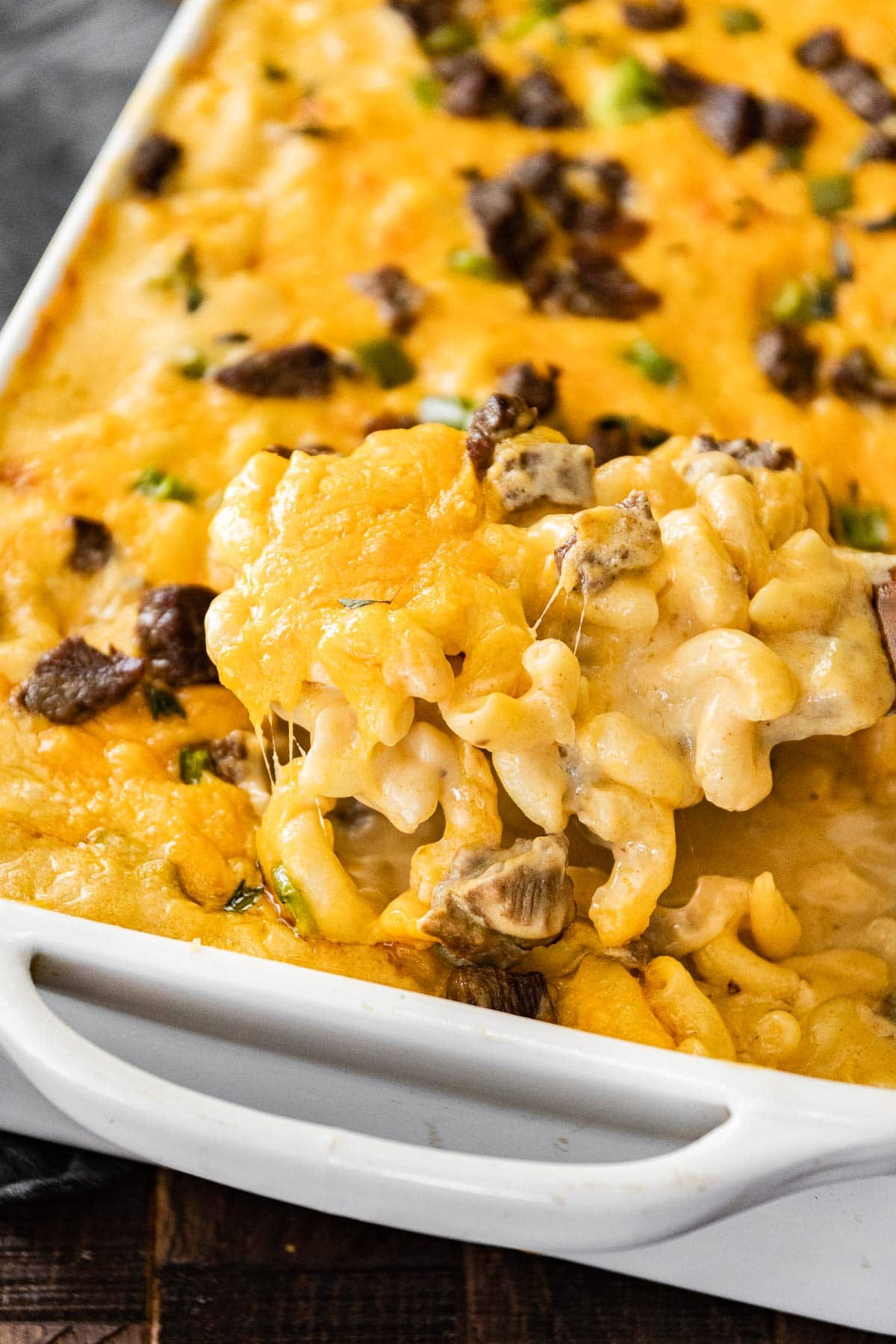 Philly Cheesesteak Mac and Cheese scooping from baking dish
