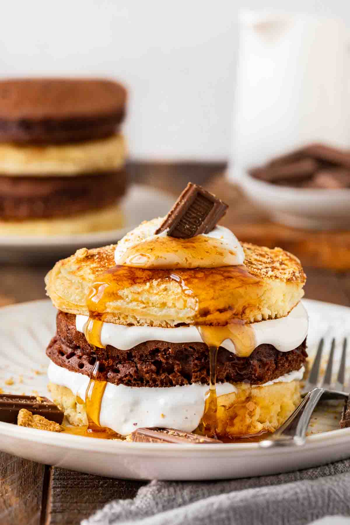 S'mores Pancakes stack with syrup and chocolate segment