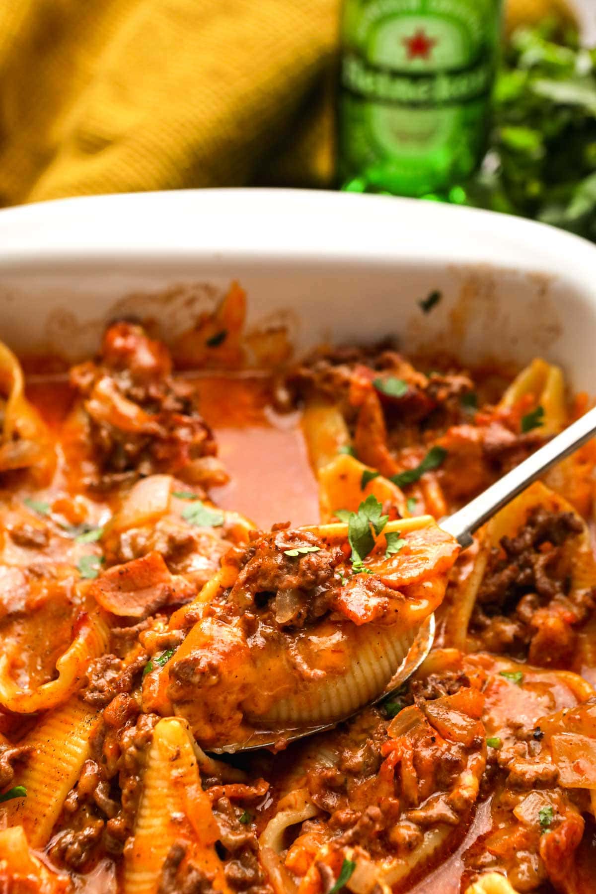 Bacon Beef Beer Stuffed Shells spooning from baking dish