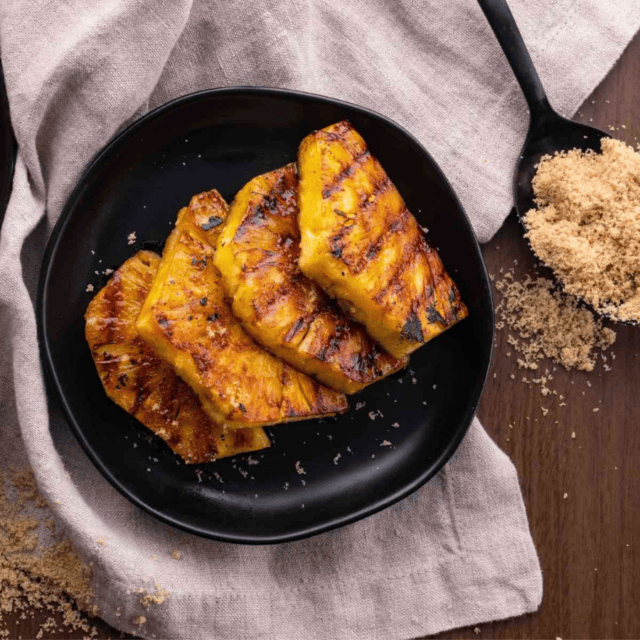 pineapple on a plate with brown sugar on the side