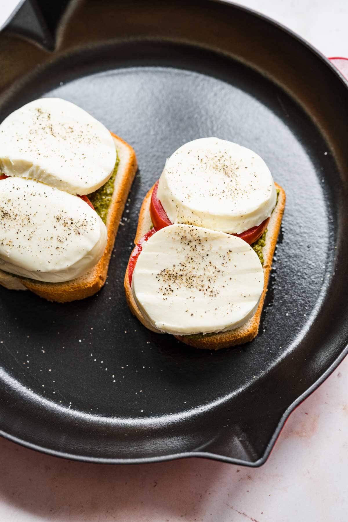 Caprese Grilled Cheese tomato and mozzarella added to bread in cooking pan