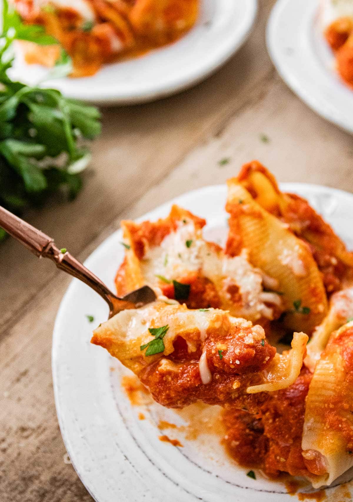 Chicken Parmesan Stuffed Shells on serving plate with closeup on fork