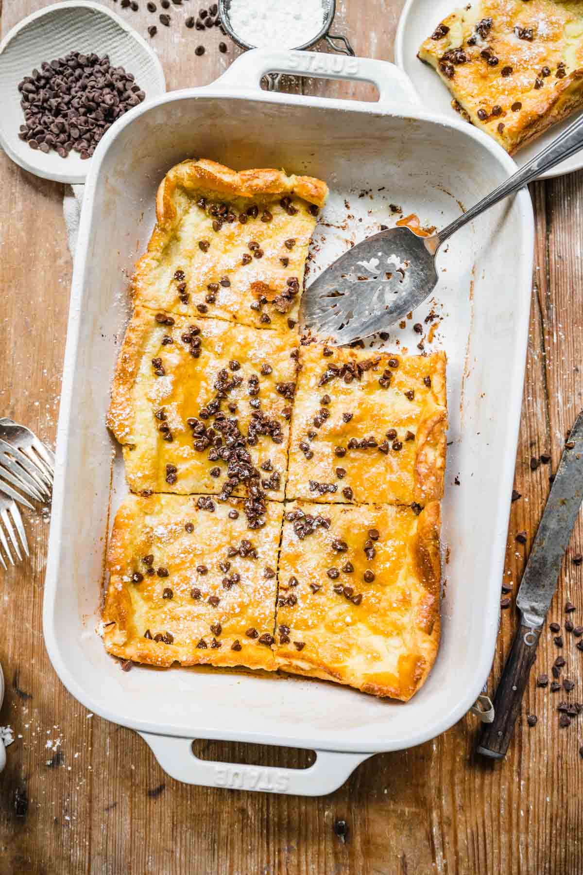 Chocolate Chip Dutch Baby in baking pan with slice removed