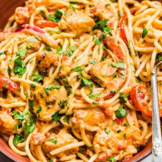 creamy noodles with tender meat and peppers with a fork