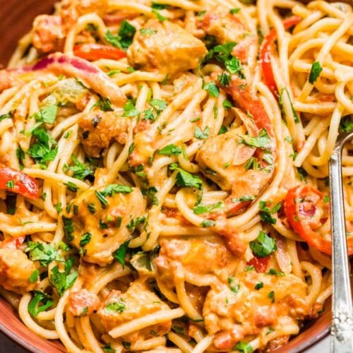 creamy noodles with tender meat and peppers with a fork