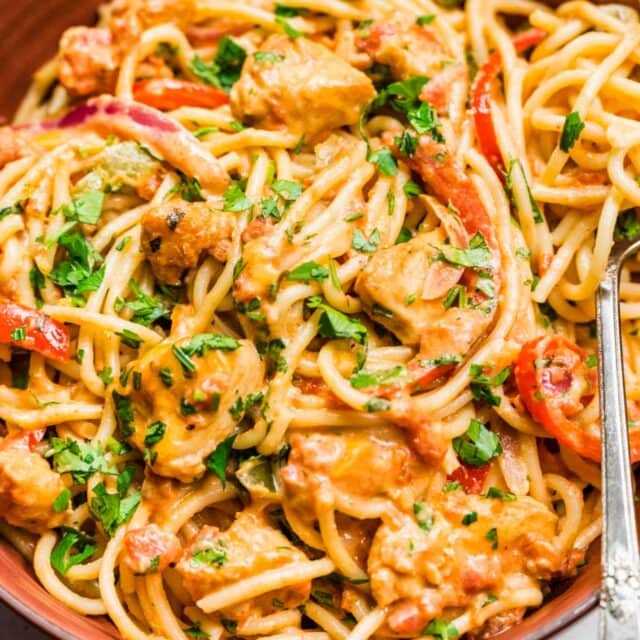 creamy noodles with tender meat and peppers with a fork