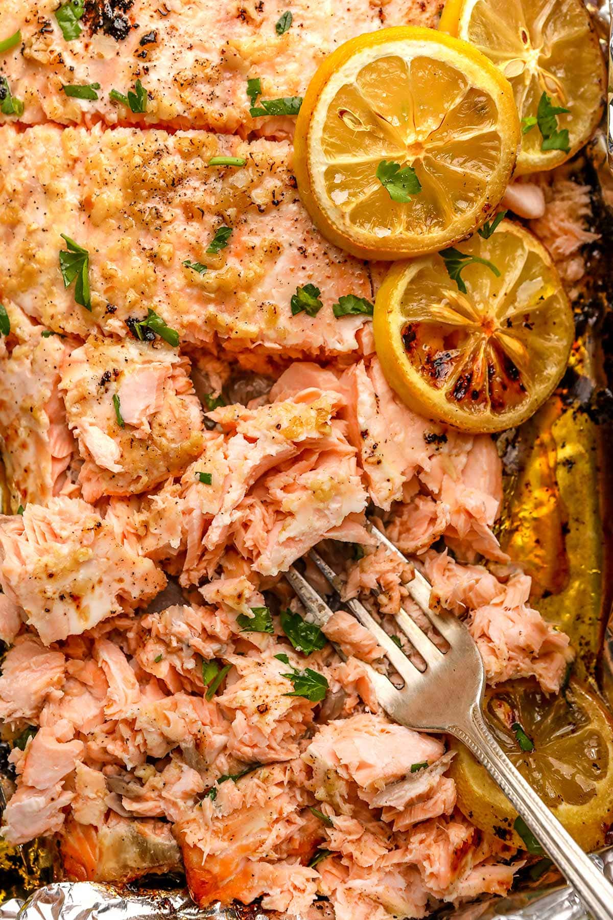 Garlic Butter Salmon sliced on fork on baking pan