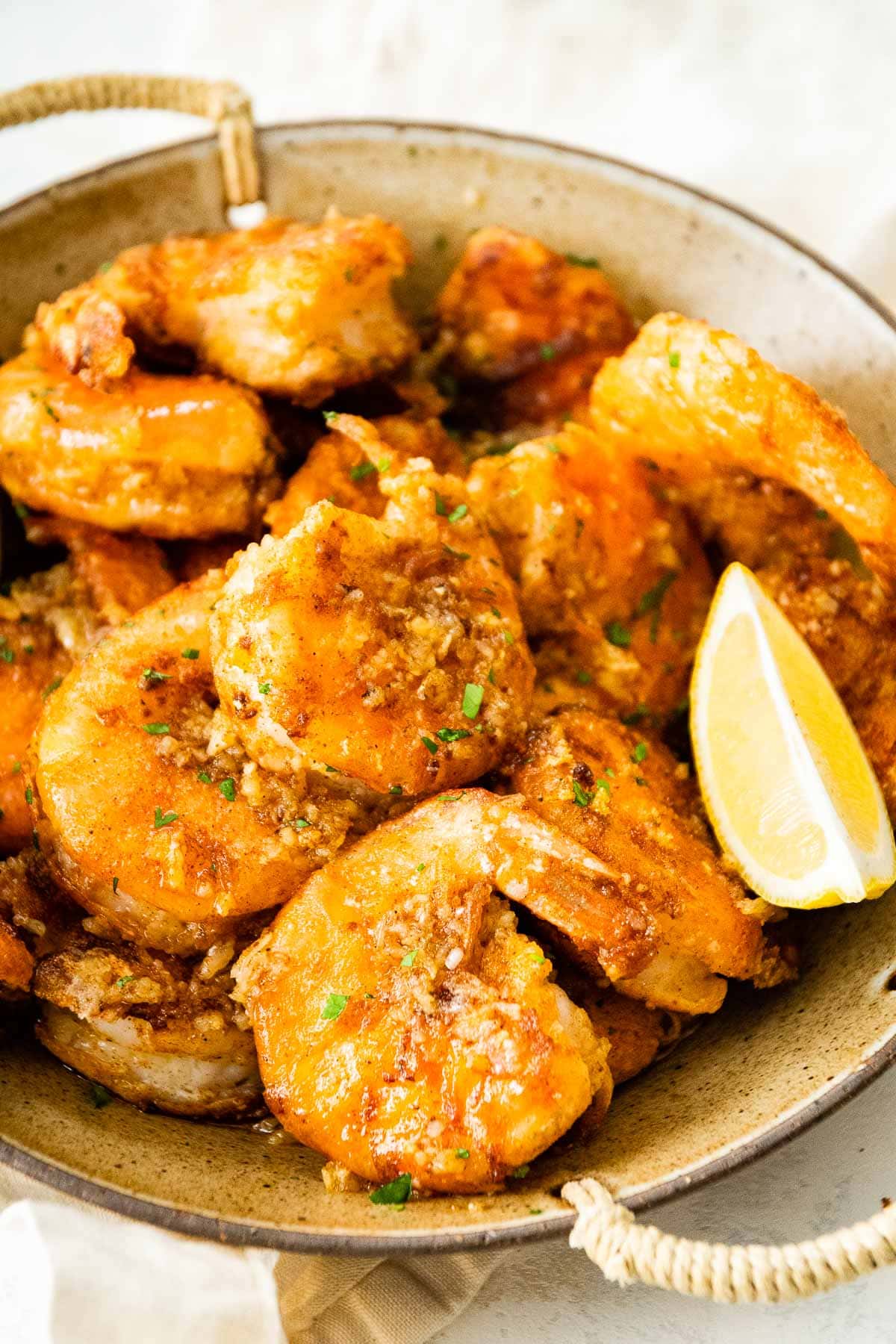 Hawaiian Garlic Shrimp in serving bowl with lemon wedges