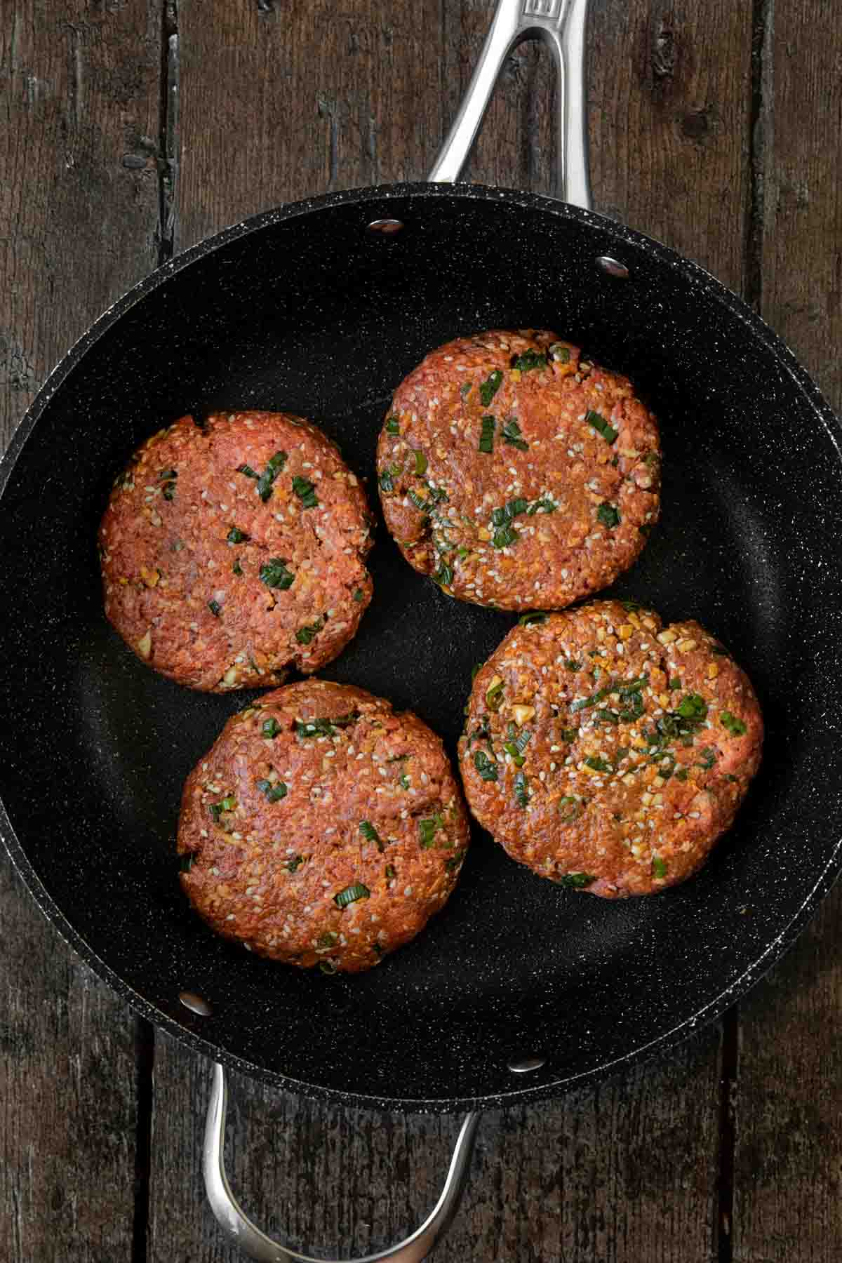 Korean Beef Bulgogi Burger patties in cooking pan before cooking