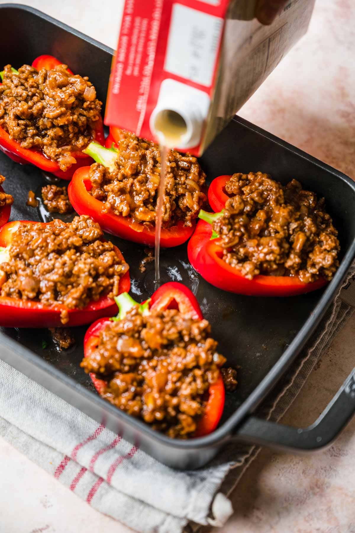 Korean Beef Stuffed Peppers adding beef broth in baking pan