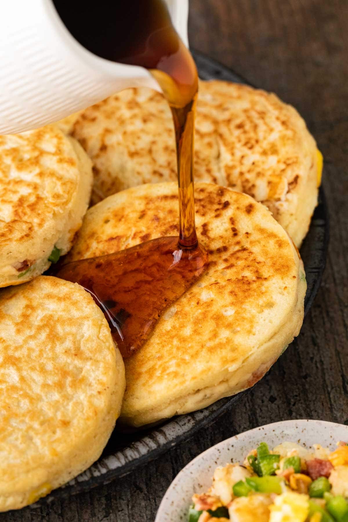 Loaded Breakfast Pancakes pouring syrup on serving platter