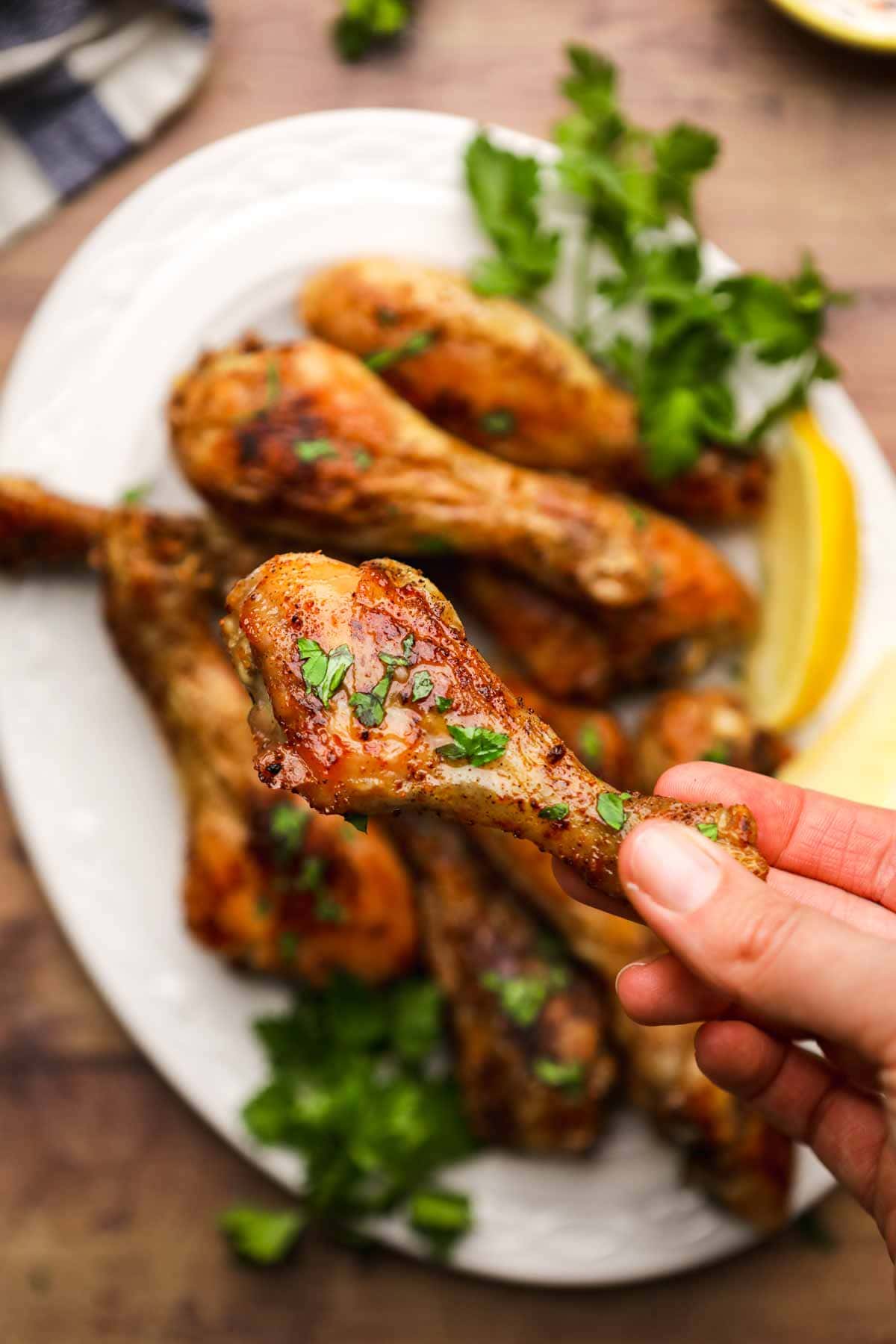 Oven Baked Chicken Drumsticks closeup in hand