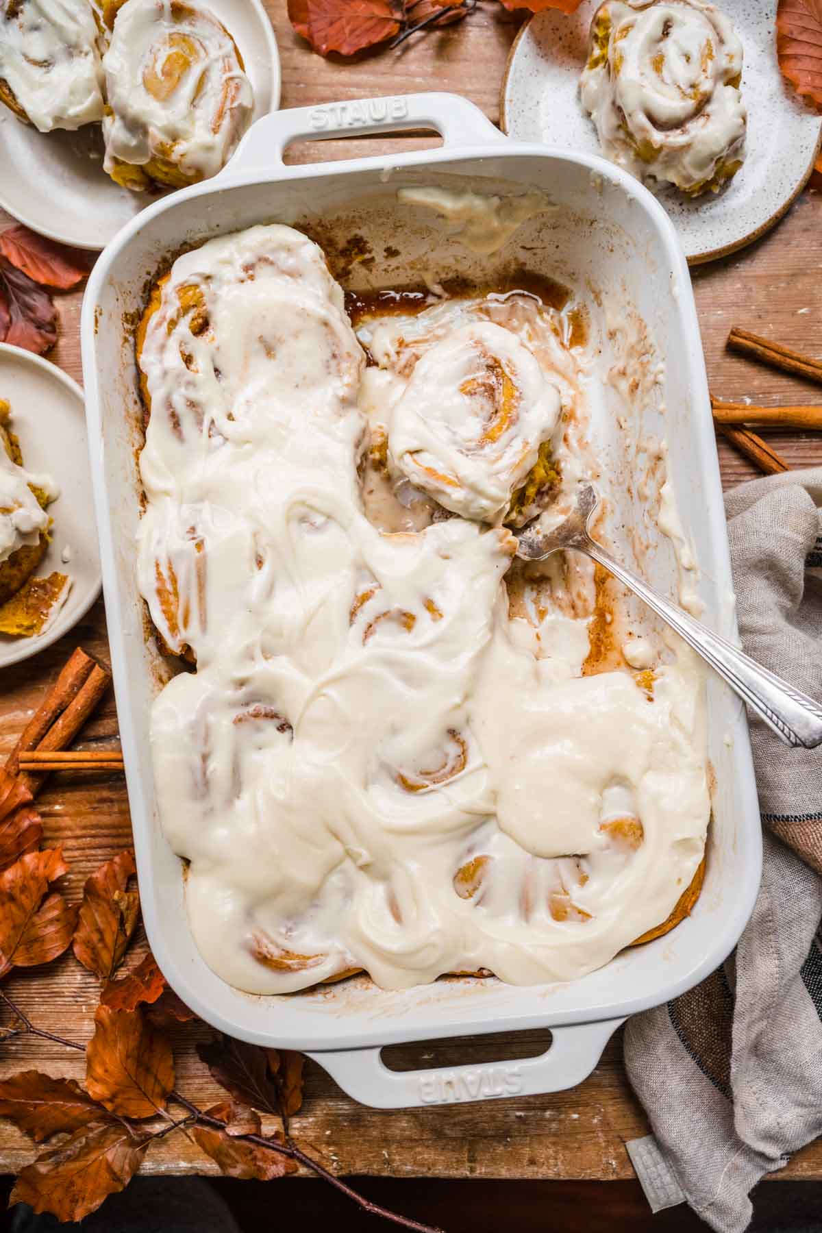 Pumpkin Cinnamon Rolls in baking pan with some removed