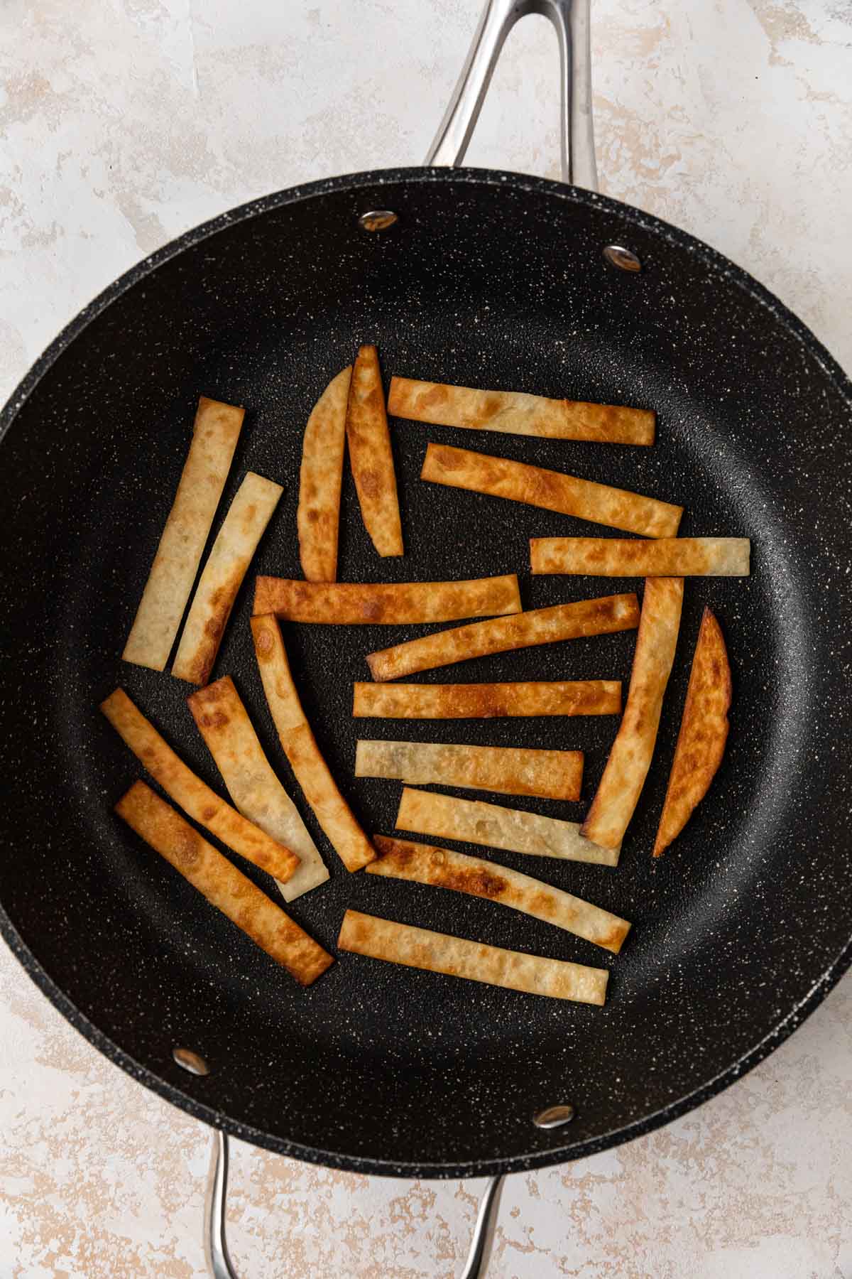 Slow Cooker Chicken Tortilla Soup tortilla strips toasting in skillet