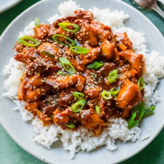 Slow Cooker Sesame Chicken on serving plate over rice 1x1