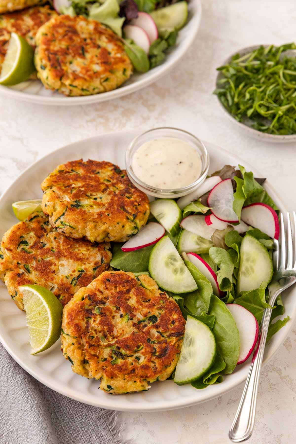 Zucchini Patties on serving plate over veggies