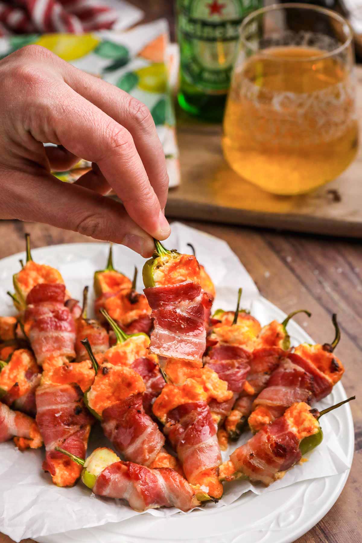Bacon Jalapeno Poppers finished on plate and hand holding one pepper