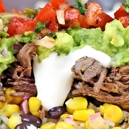 tomatoes, guac, shredded meat, corn, and sour cream piled on one another