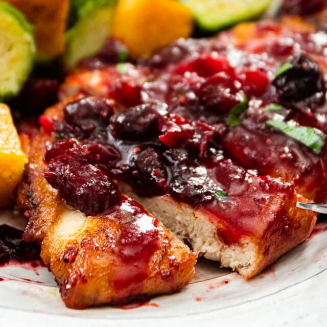 Chicken sliced on serving plate topped with cranberry sauce 4x3