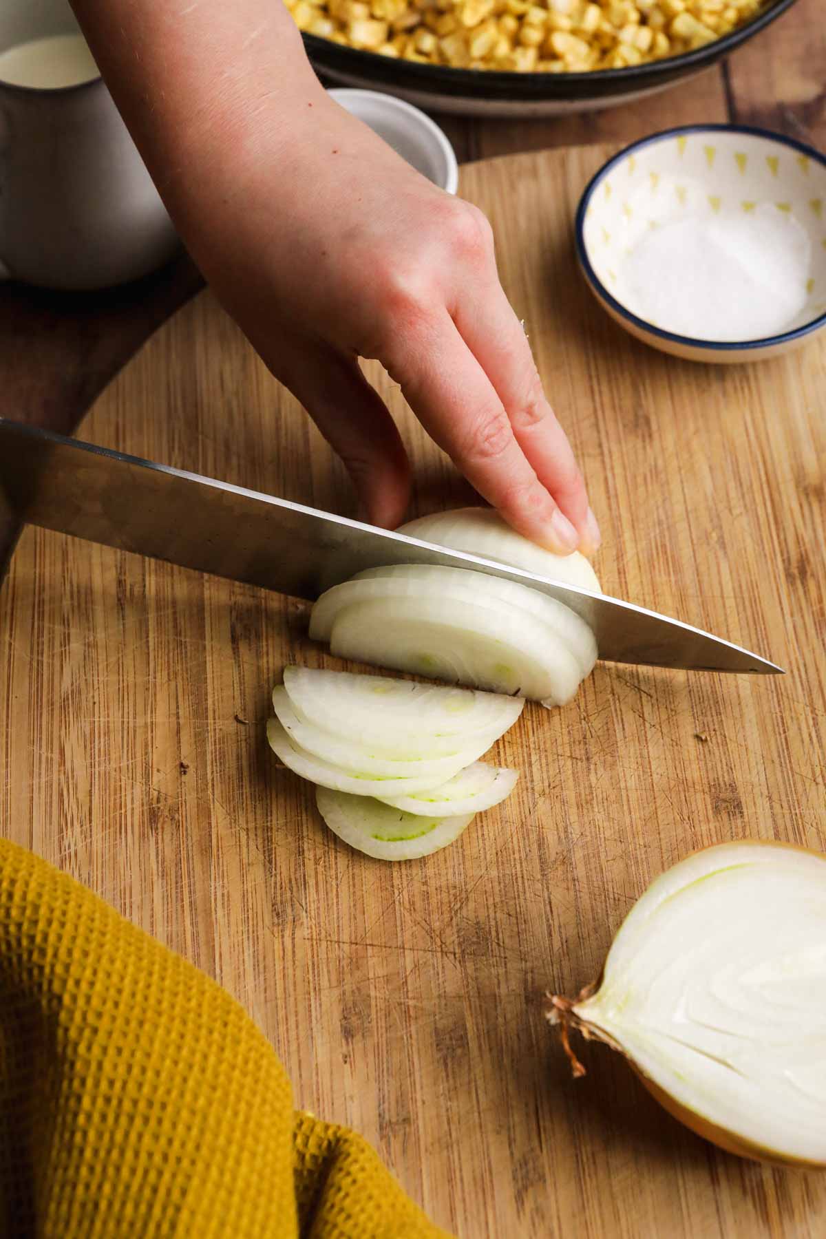 Creamed Corn slicing onion on cutting board
