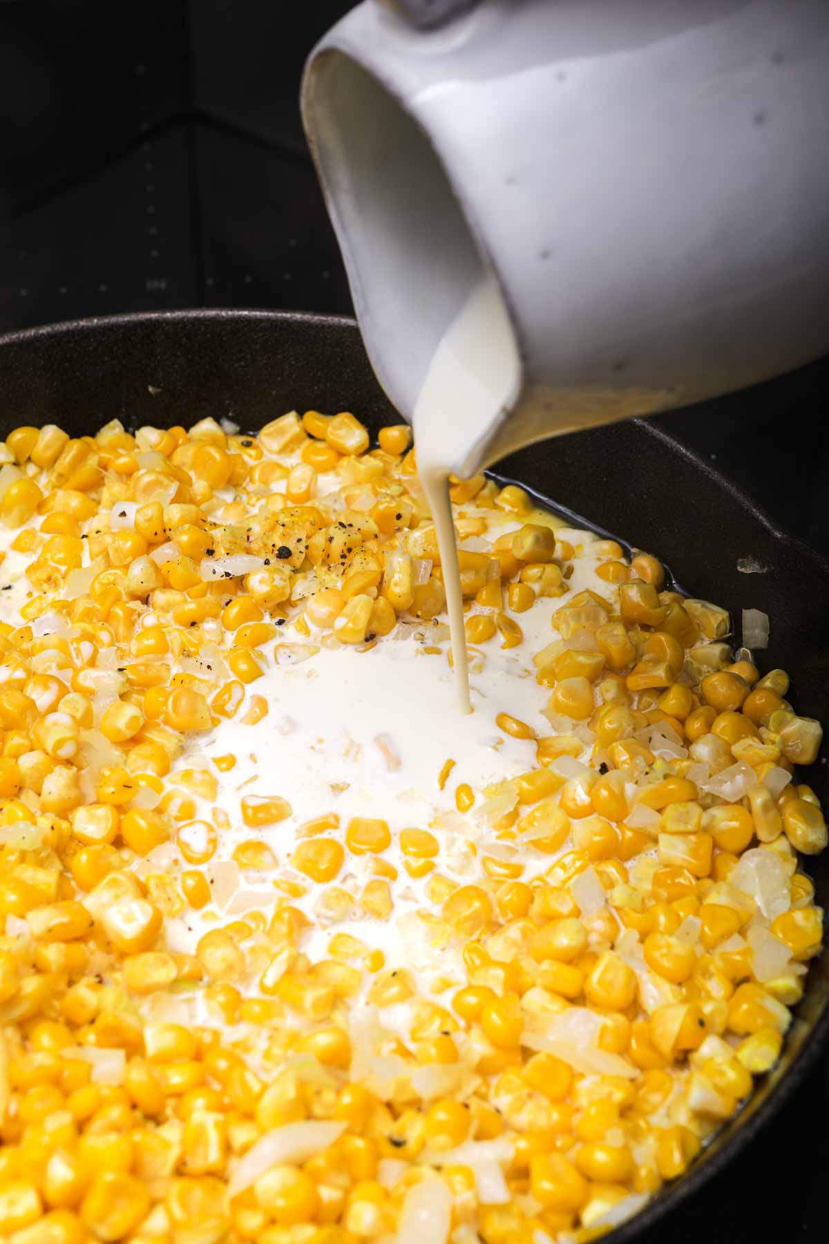 Creamed Corn adding cream mixture to cooking pan