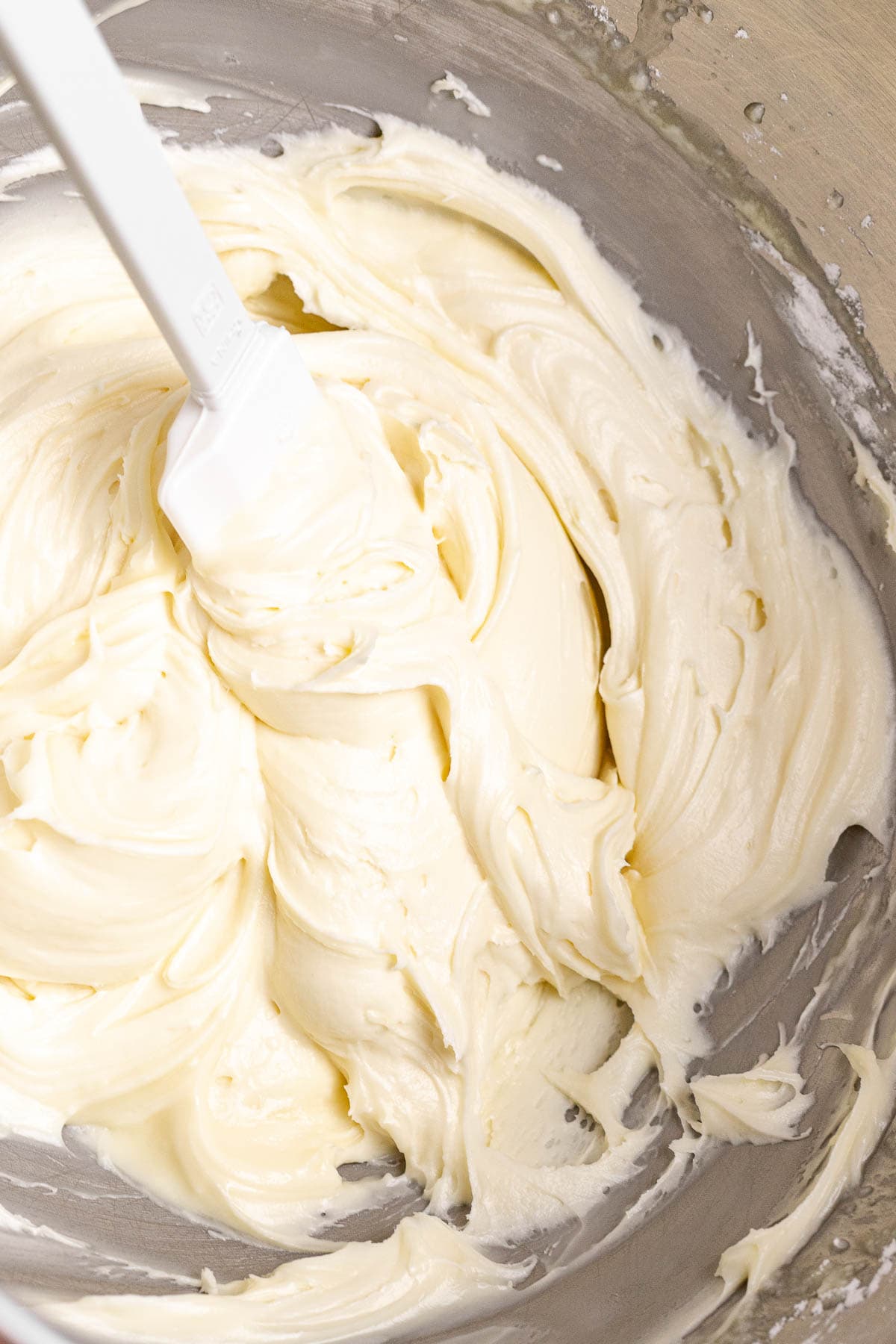 Eggnog Cookies frosting in mixing bowl with spatula