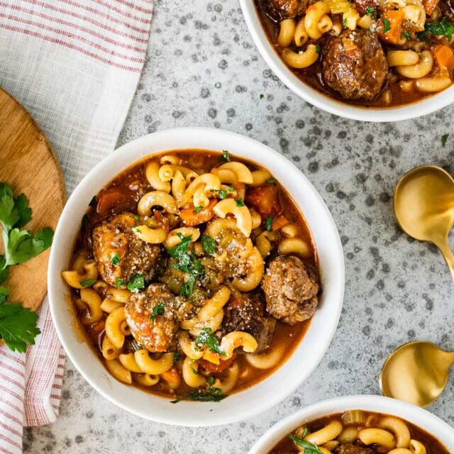 Bowl of soup with pasta, meatballs, and vegetables.