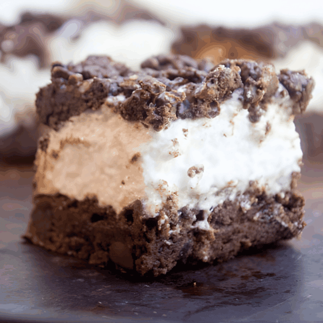 rich fudgy square topped with a white fluffy layer with crumbles on top
