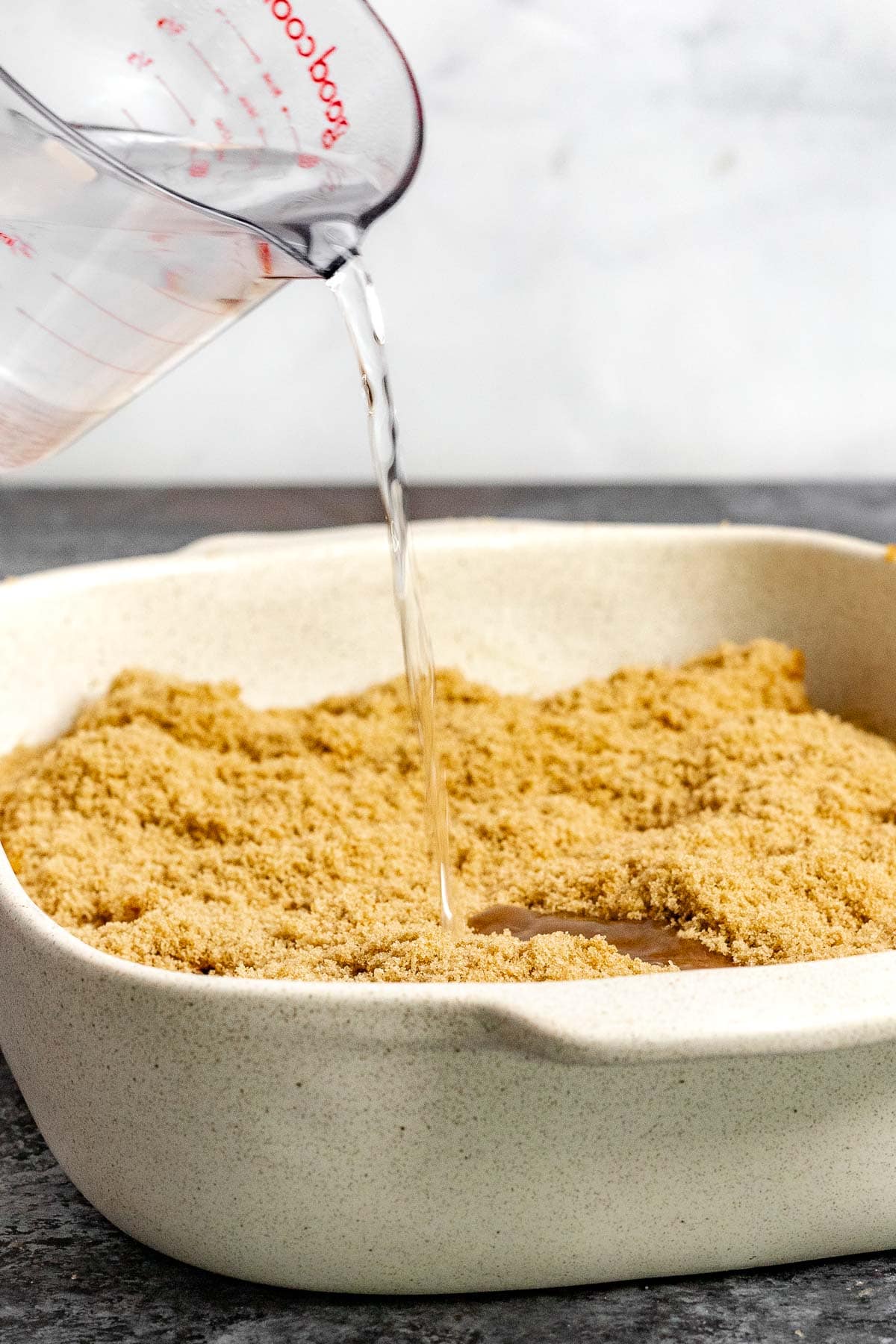 Pumpkin Cobbler pouring water on unbaked cobbler in dish