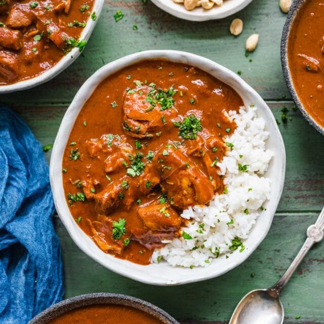 red chili pork in bowl with rice garnished with cilantro