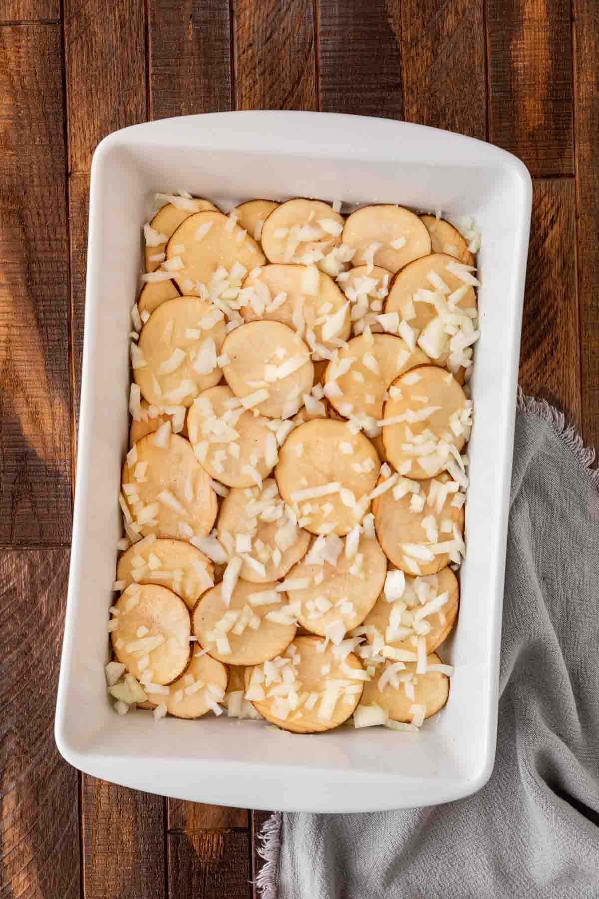 Scalloped Potatoes and Ham potato and onion layer in baking dish