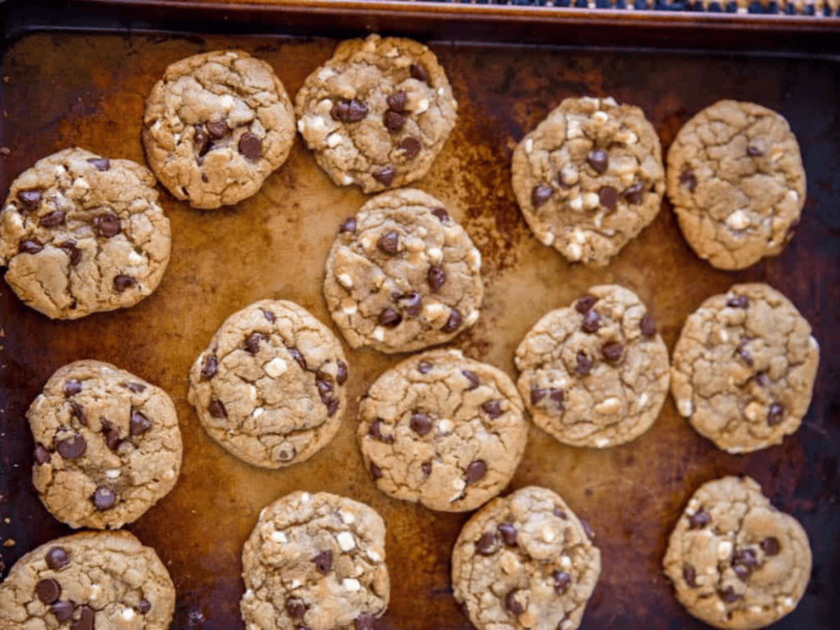 Baking sheet with cookies on top that contain chocolate and marshmellows.