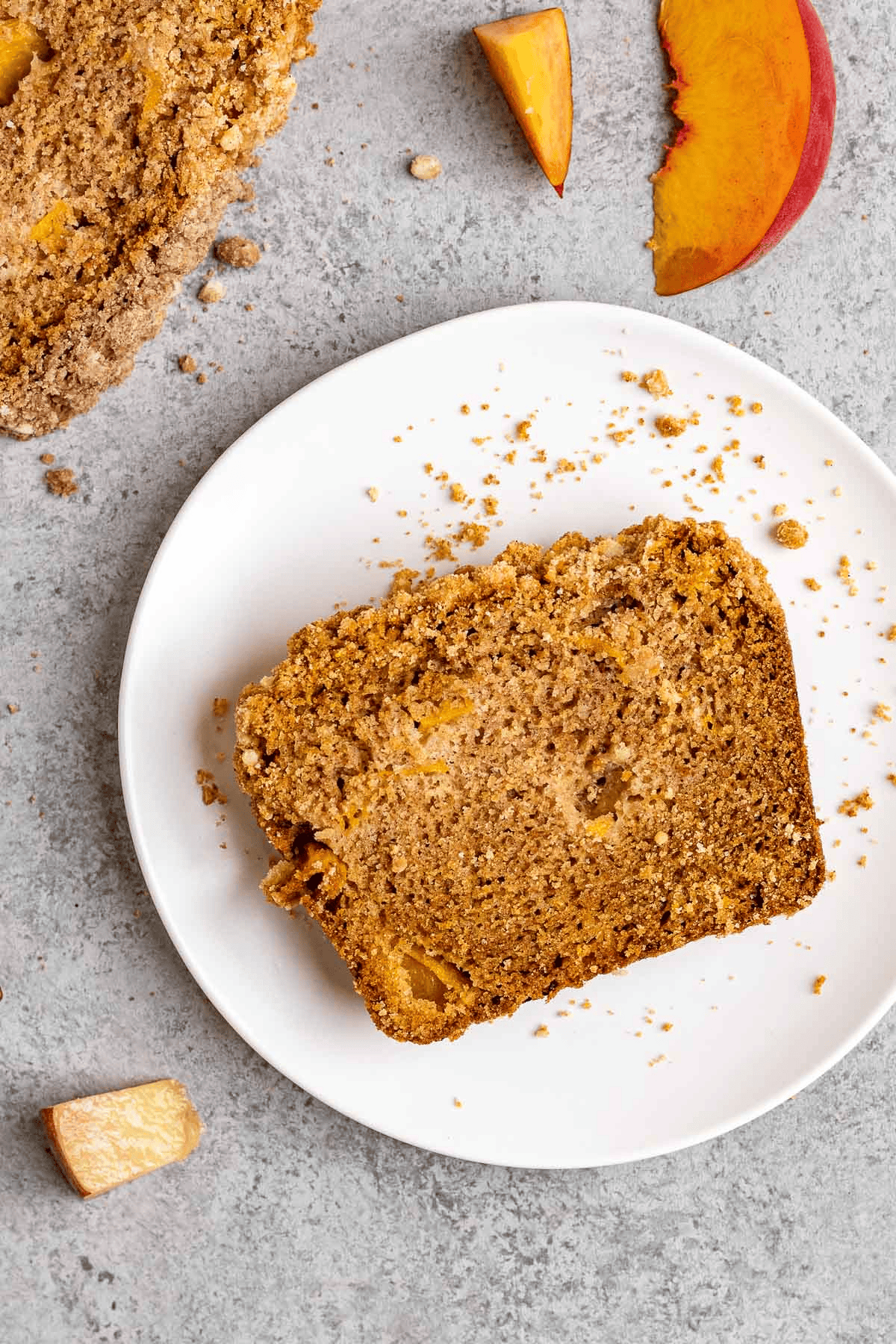 Slice of bread with streusel falling off on a white plate