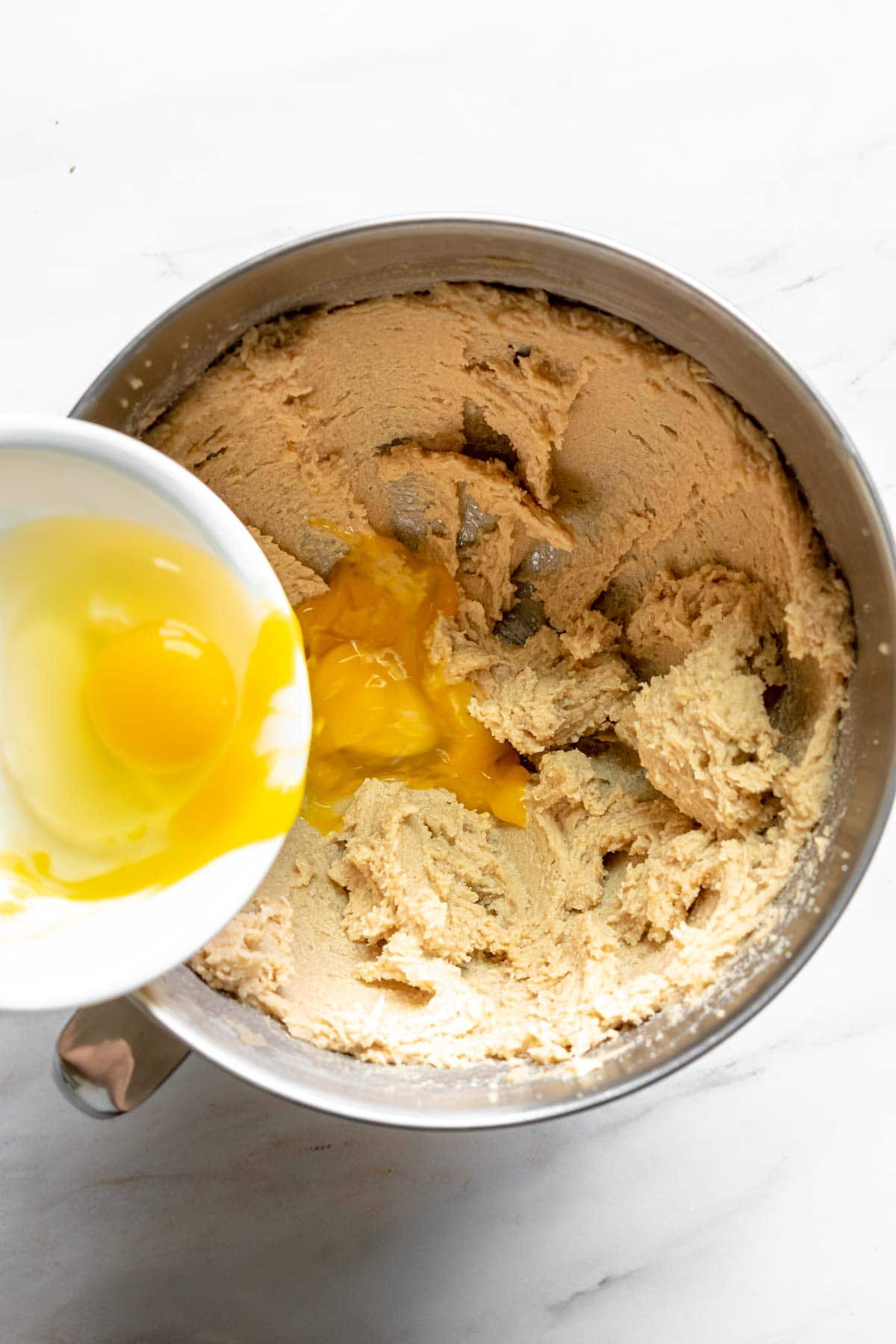 Chocolate Chipless Cookies adding eggs to dough in mixing bowl