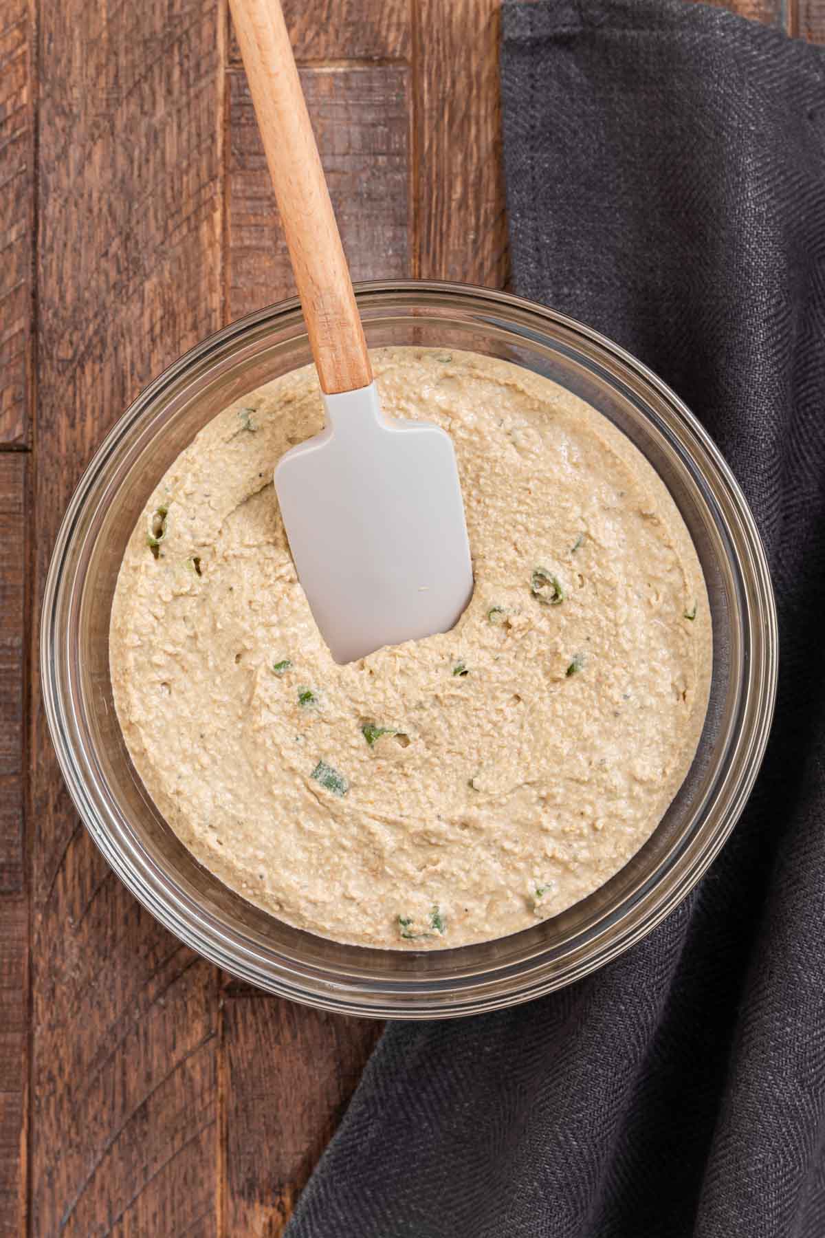 Clam Dip mixed in large glass mixing bowl with spatula